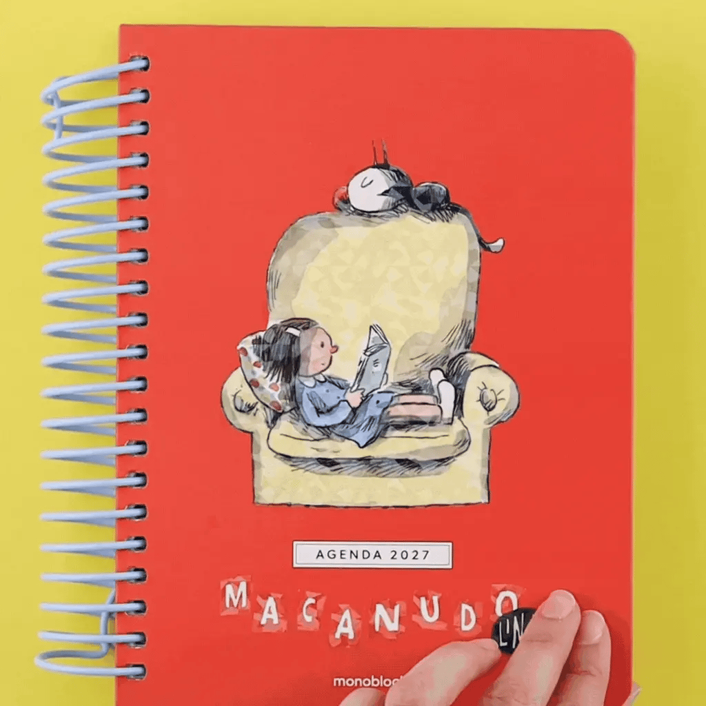 Animación de una mano abriendo la agenda Macanudo de Liniers con organización diaria para 2027