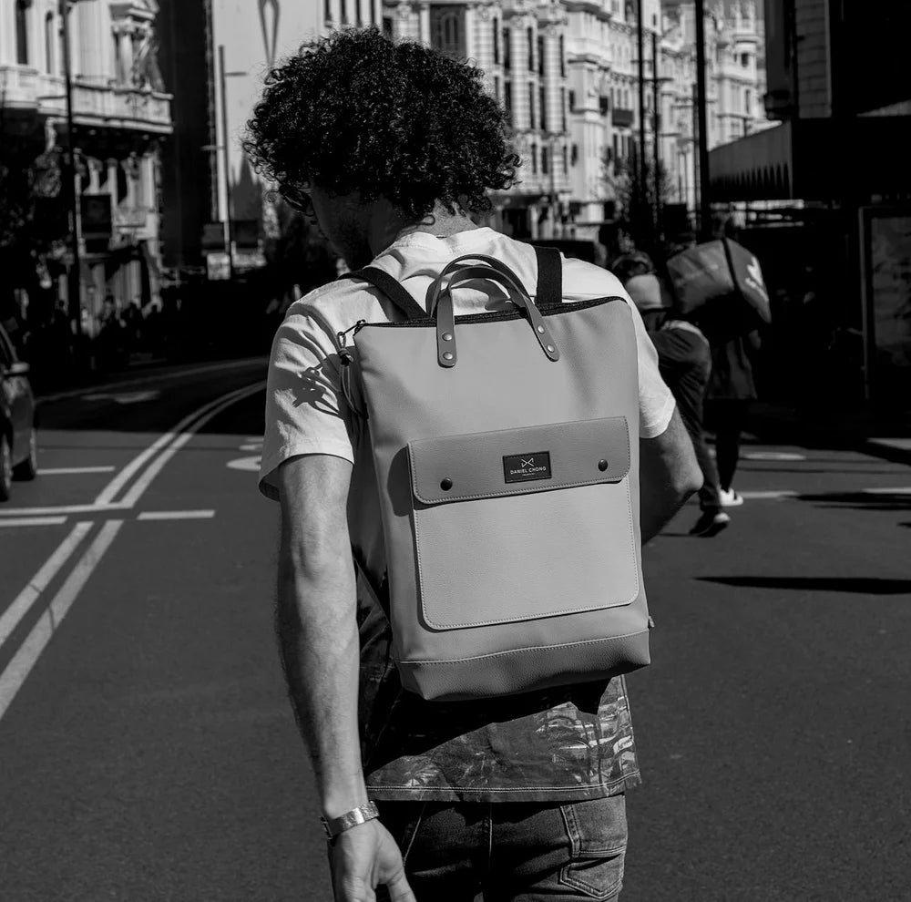 Chico andando por la calle con una mochila de Daniel Chong