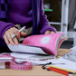 Mujer con jersey morado consultando la agenda Happimess Mi Superplán 2027 sobre una mesa de trabajo con un metro de costurera encima