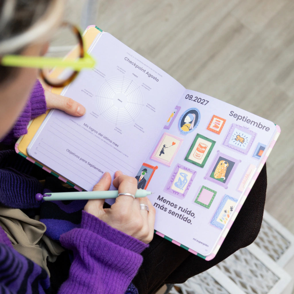 Persona escribiendo en la agenda Mi Superplán 2027 Rainbow Dancer con página de septiembre abierta