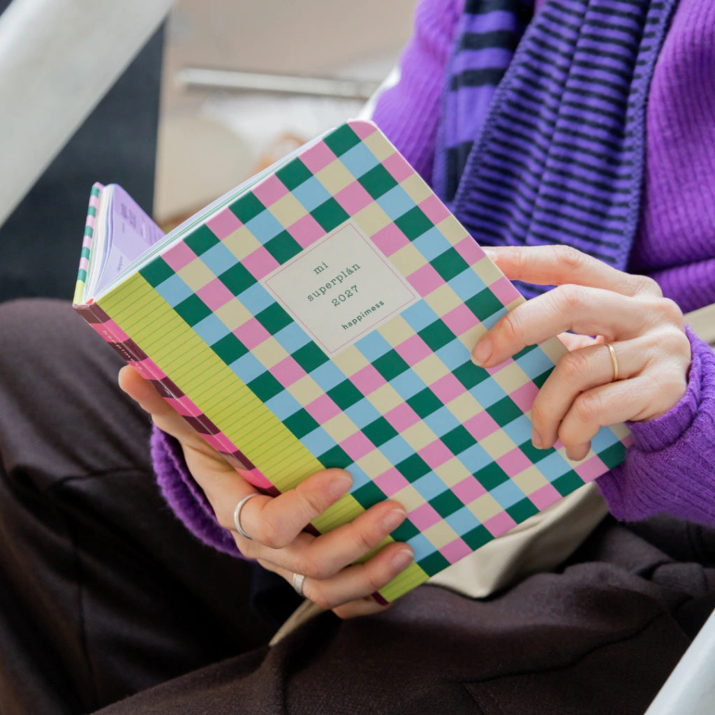 Mujer con jersey morado y la Agenda Mi Superplán 2027 Rainbow Dancer Happimess en las manos