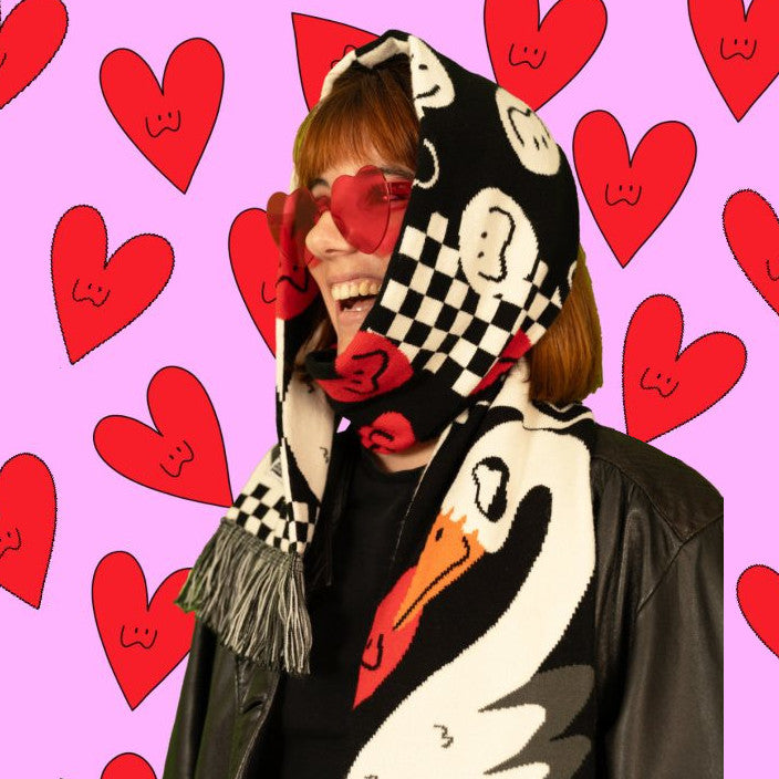 Detalle de la textura y acabado de la bufanda Swan Romance, con una modelo llevando la bufanda por encima de la cabeza