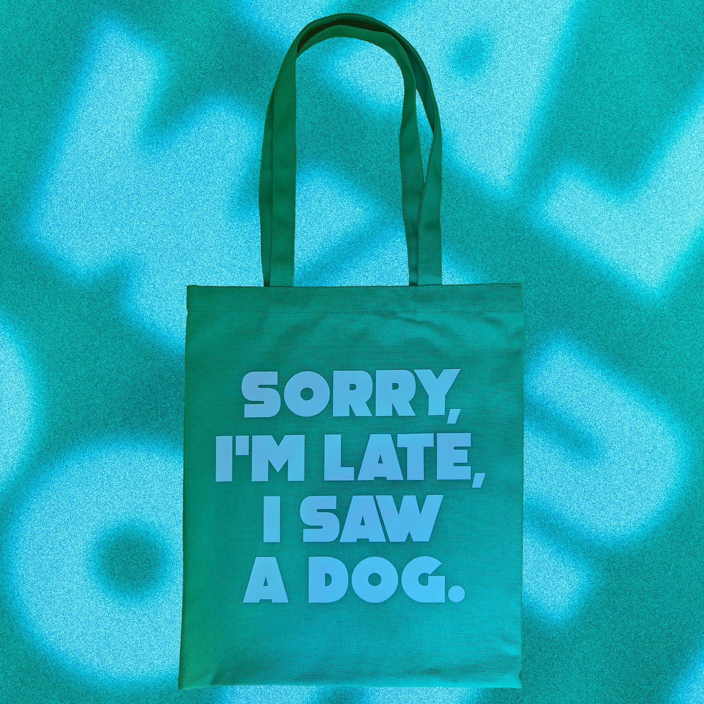 Tote Bag de tela verde con el mensaje "sorry i'm late, I saw a dog" escrito en letras mayúsculas azules