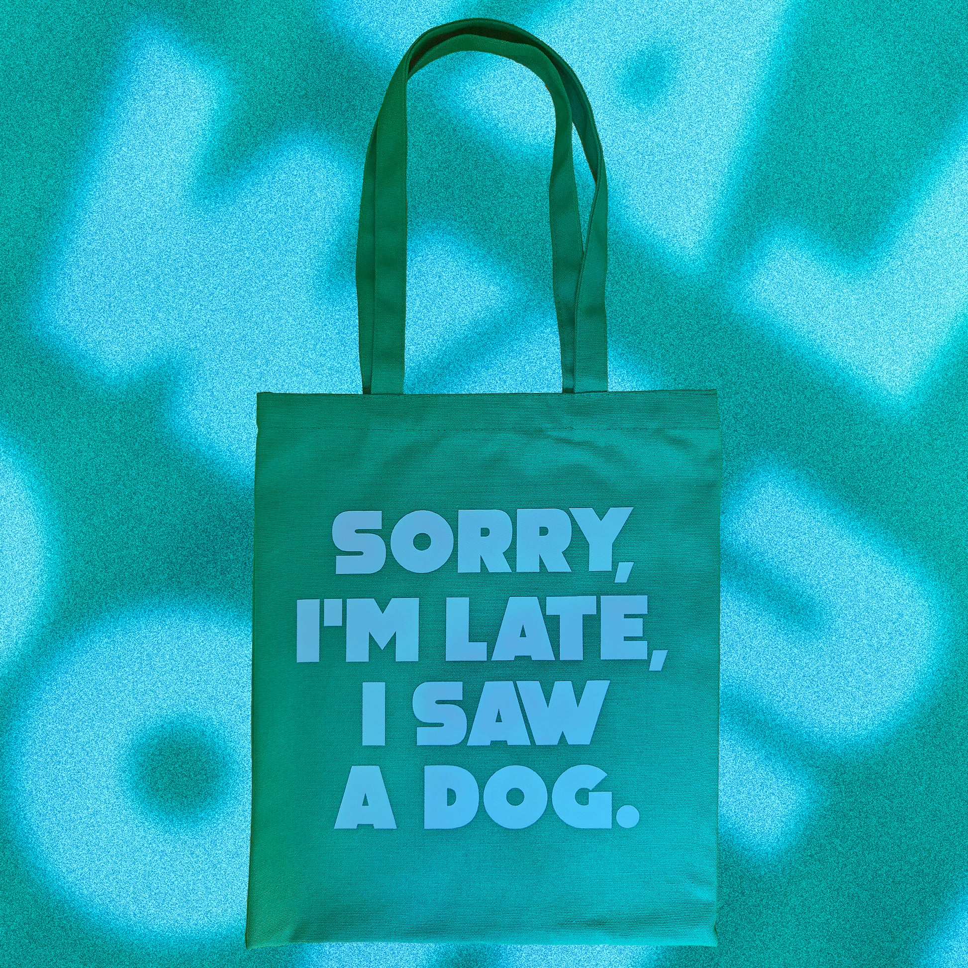 Tote Bag de tela verde con el mensaje "sorry i'm late, I saw a dog" escrito en letras mayúsculas azules