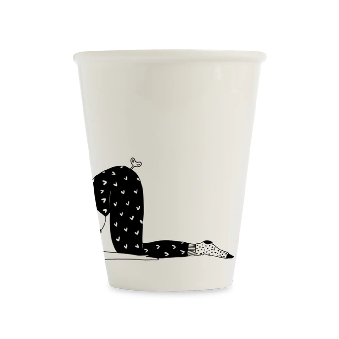 Taza blanca donde salen las piernas de una mujer que está durmiendo. 