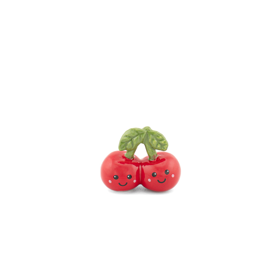Token de dos cerezas con caras sonrientes en fondo blanco. 