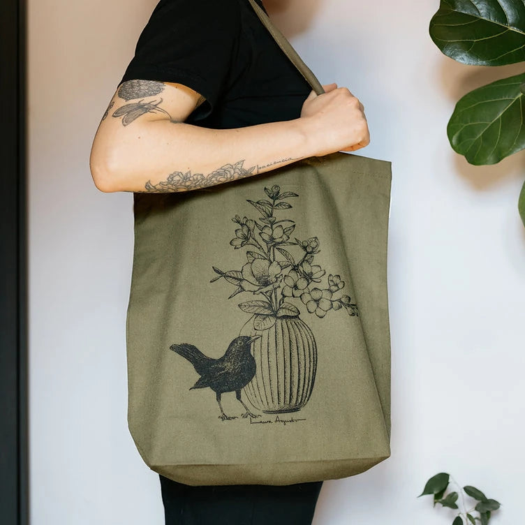 Tote bag verde oscuro con ilustración de laura Agustí de un jarrón con un mirlo