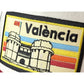 Detalle del parche de la gorra Blanca con visera roja y parche con el texto València y las torres de serrano bordadas