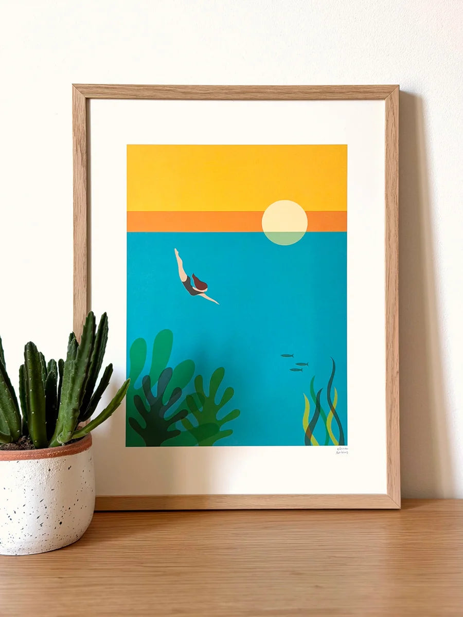 Ilustración de una chica zambulléndose en el mar azul con pececillos, algas y una puesta de sol de fondo en un marco 30x40 color madera 