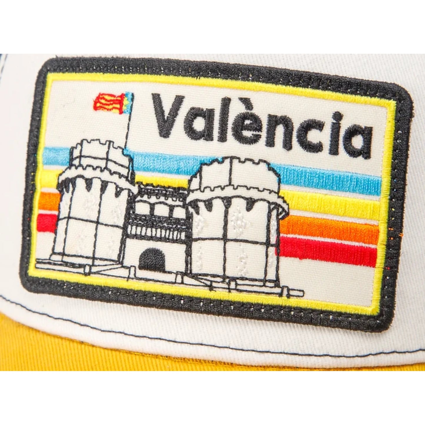 Detalle de Gorra Blanca con visera amarilla y parche con el texto València y las torres de serrano bordadas