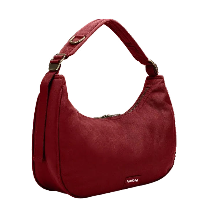 Bolso burdeos Bianca de Hindbag visto de perfil sobre fondo blanco, con el asa acolchada, la hebilla ajustable y la anilla metálica en detalle.