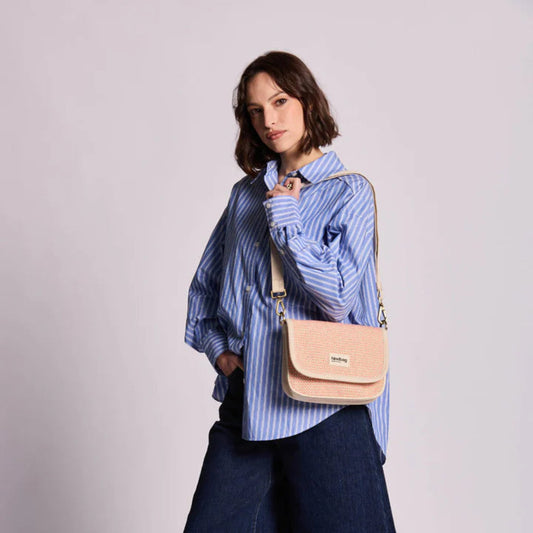mujer sujetando bolso de la marca hindbag color coral