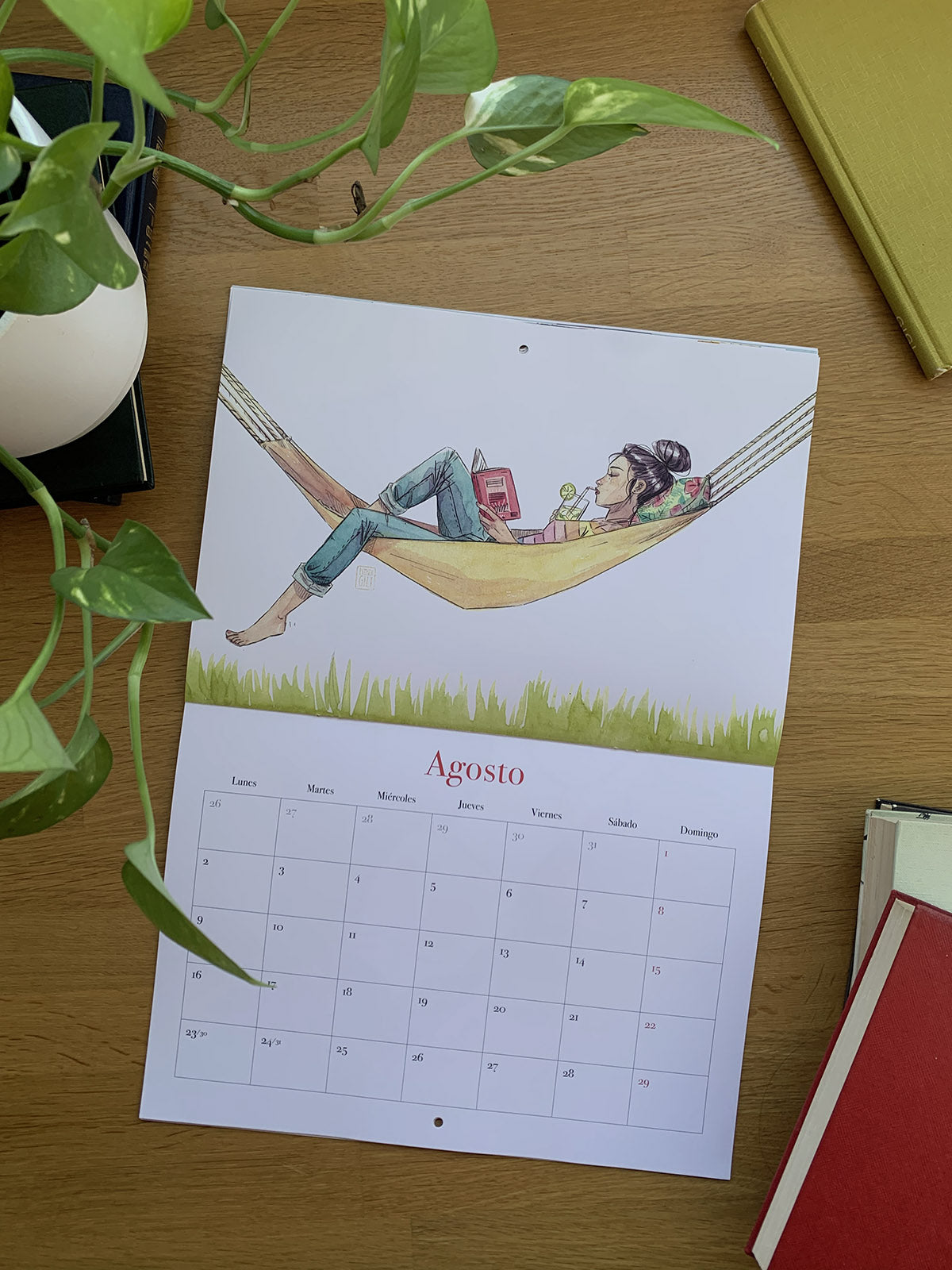 Calendario 2027 Leyendo abierto en agosto, con una mujer leyendo en una hamaca.