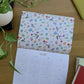Calendario 2027 Leyendo abierto en la vista anual de 2028, con una ilustración de libros, golondrinas y flores.