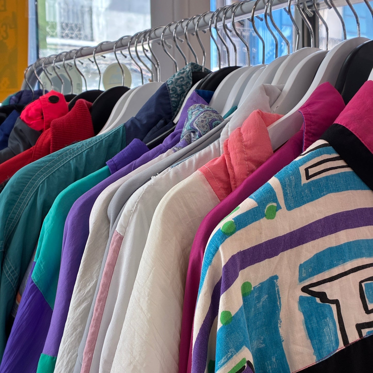 Chándales vintage de varios colores colgados en perchas