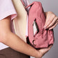 Detalle de los compartimentos de la sling bag de Hindbag en color rosa con cremalleras en sus tres bolsillos principales