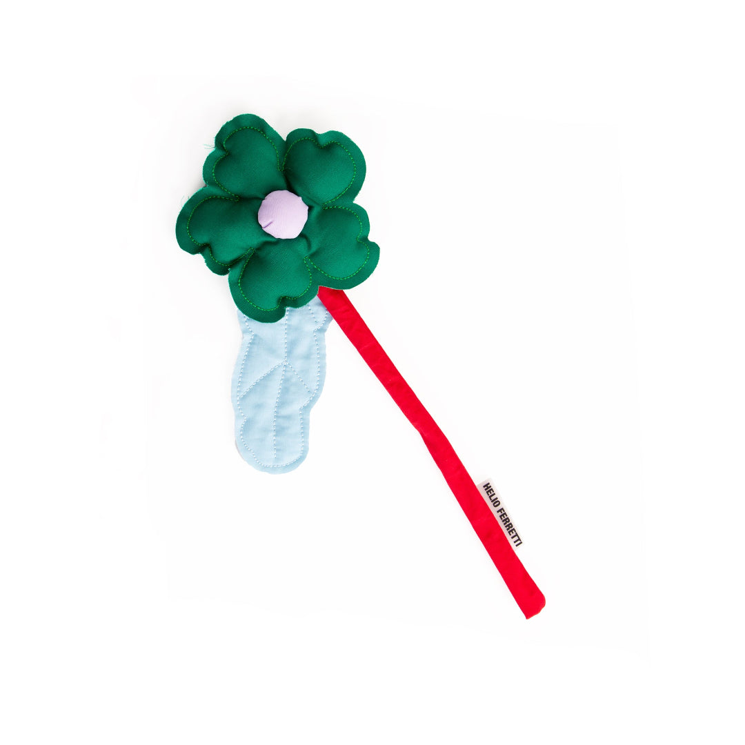 flor de tela decorativa de la marca Helio Ferretti en color verde con el tallo rojo y una hoja en azul celeste