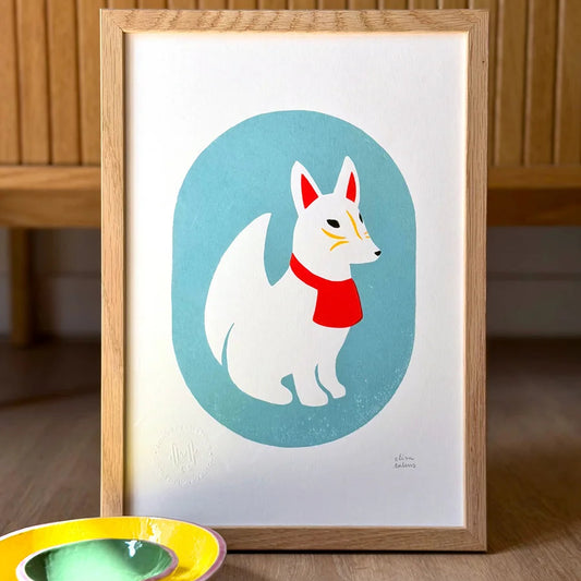 Serigrafía de estilo japonés con un Kitsune blanco con detalles rojos y amarillos sobre fondo azul. Al fondo se ven otras ilustraciones con motivos japoneses. 
