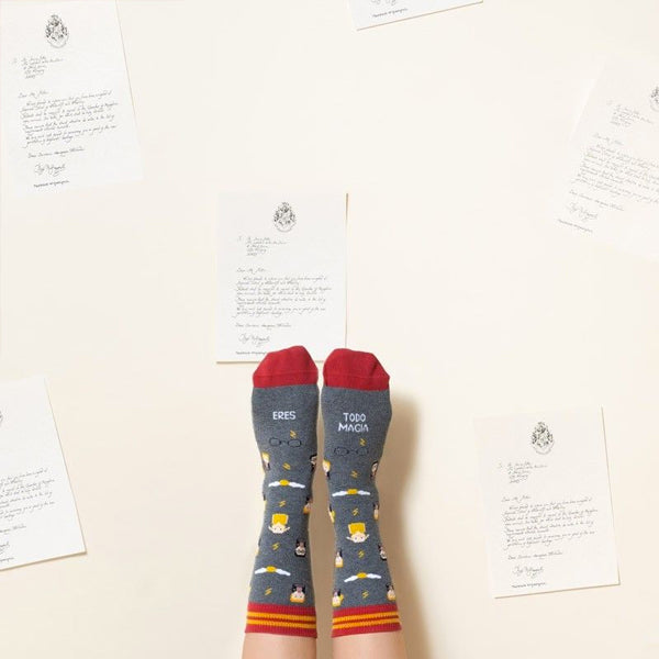 Pies con los calcetines de Harry Potter junto a muchas cartas de admisión de Hogwarts