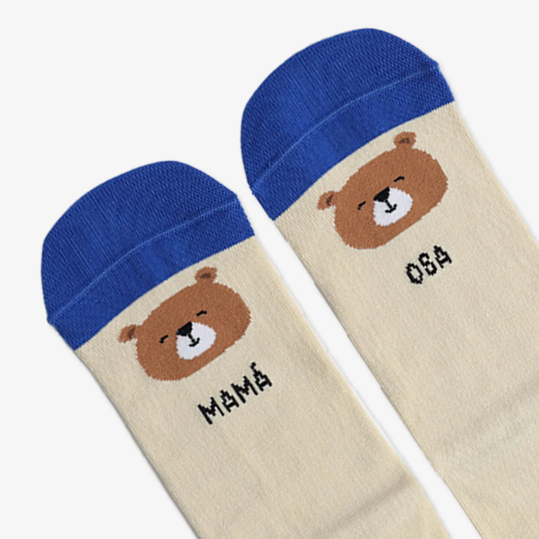 Detalle de los calcetines para regalar el día de la madre en color beige con la puntera azul, la cara de un oso y el texto "Mamá Osa"