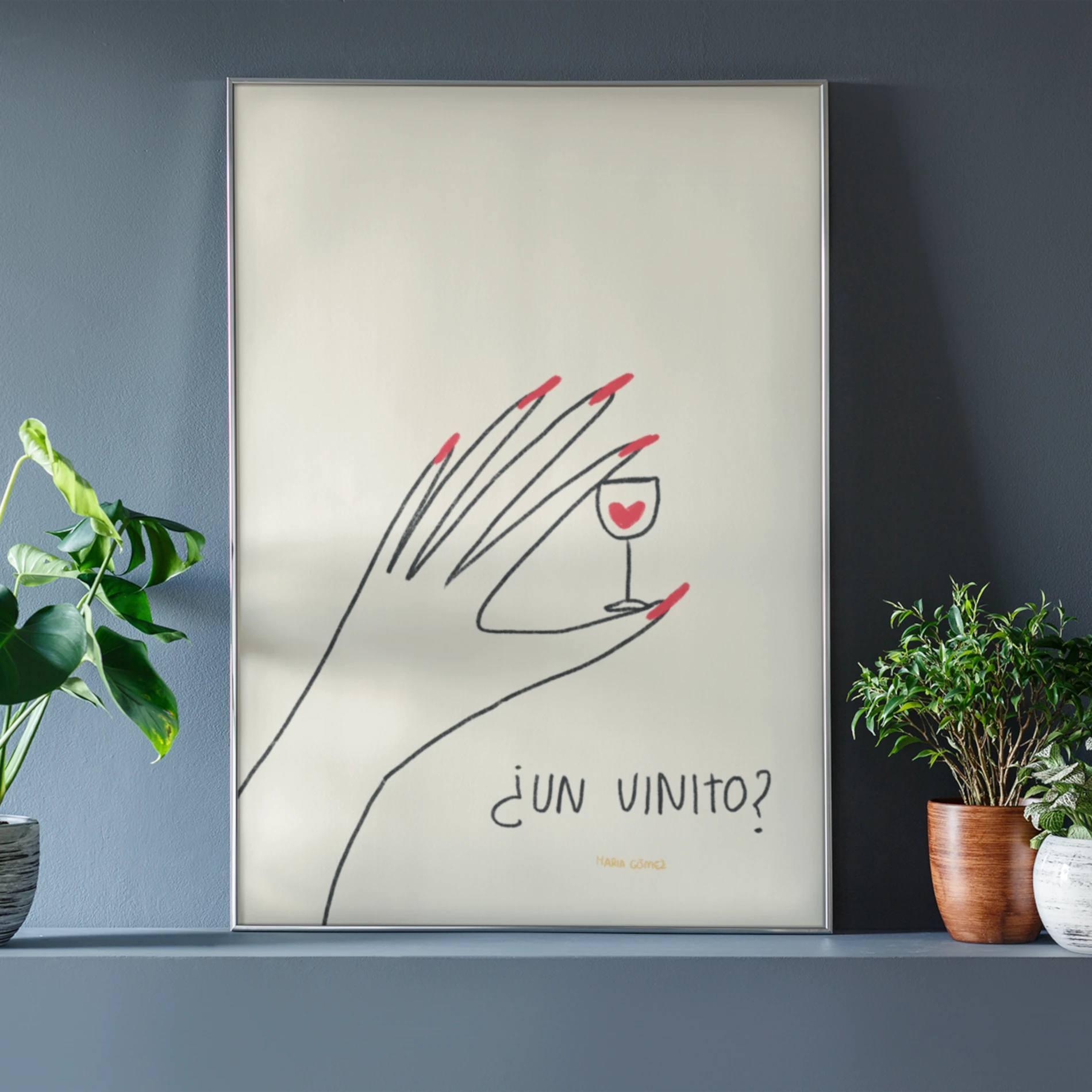 mockup de la ilustración ¿un vinito? de María Gómez, en un marco de metal apoyado en una pared y con plantas alrededor