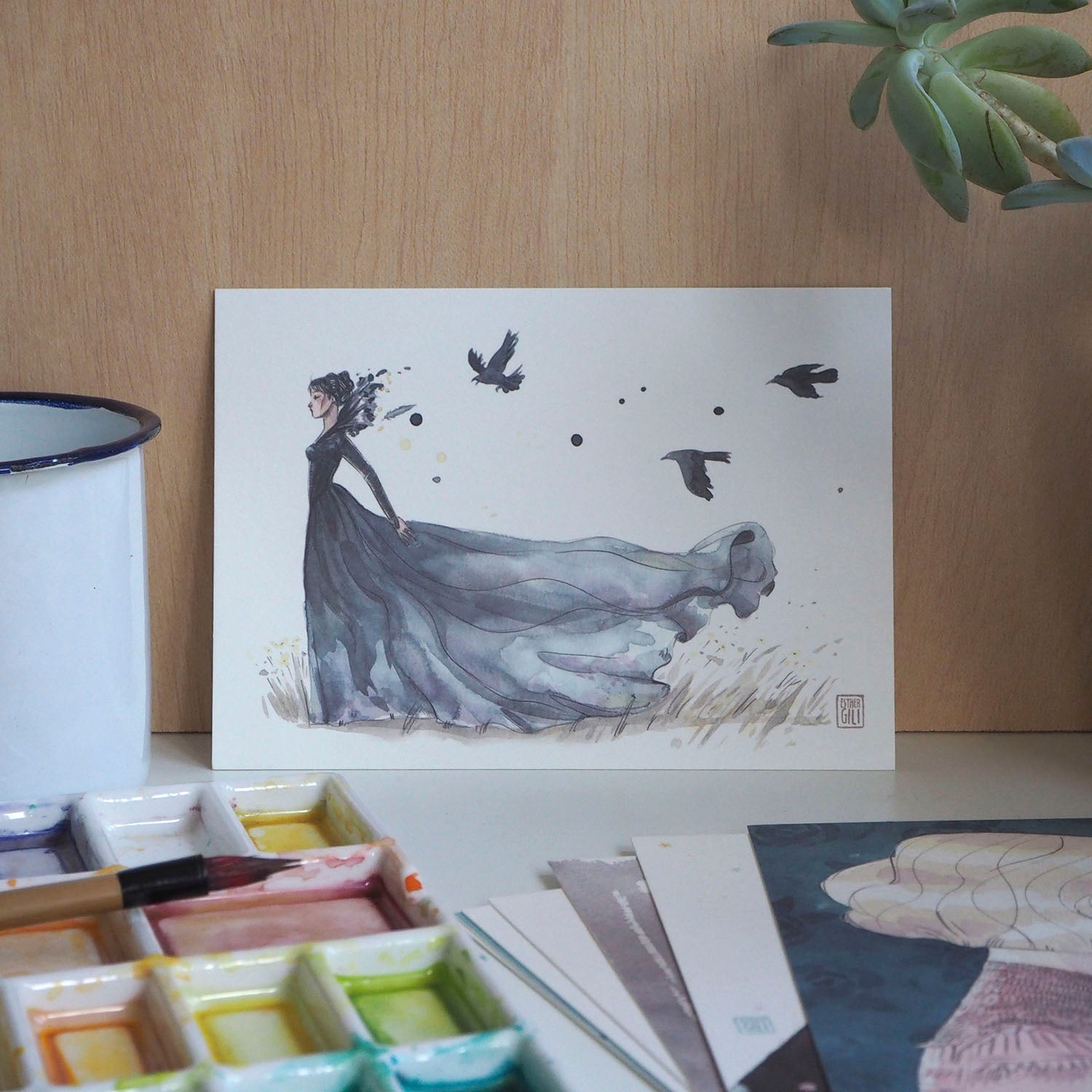 Postal de Esther Gili con ilustración de una mujer con un traje negro vaporoso seguida por cuervos