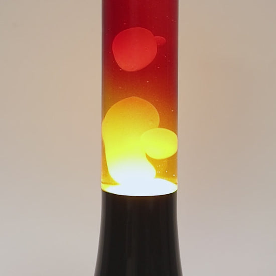Lámpara lava con base cromada en negro y liquido amarillo y rojo