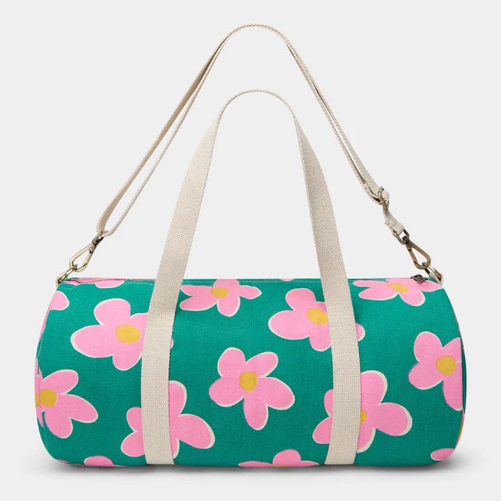 parte de detrás de la bolsa de viaje Simon de la marca Hindbag en colaboración con We are Jolies en color verde con patrón de flores rosas con el centro amarillo y las asas beige