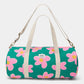 parte de delante de la bolsa de viaje Simon de la marca Hindbag en colaboración con We are Jolies en color verde con patrón de flores rosas con el centro amarillo y las dos asas beige