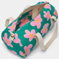 vista por dentro de la bolsa de viaje Simon de la marca Hindbag en colaboración con We are Jolies en color verde con patrón de flores rosas con el centro amarillo y las asas beige, con un bolsillo interior con el mismo patrón de flores y con cremallera