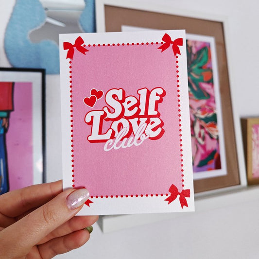 postal con el texto "Self love club" en letras blancas y rojas y con fondo rosa