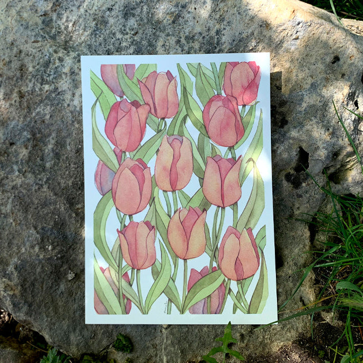 Ilustración de tulipanes naranjas en acuarela dibujada por Marialu Gili sobre una roca