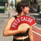 Mujer de perfil en Valencia abanicándose con un abanico en el que se lee "Puto calor" en blanco sobre fondo rojo