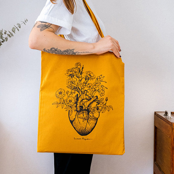 La ilustradora Laura Agustí con la bolsa de tela Flowered Heart en color naranja azafrán