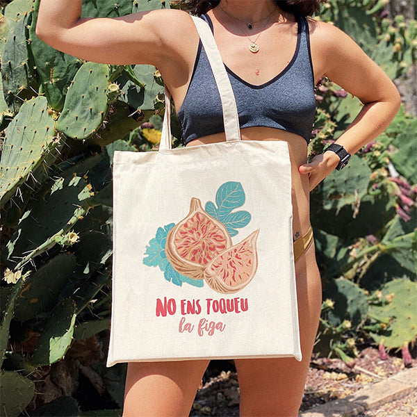 Mujer sacando músculo con la bolsa ilustrada con el texto "No ens toqueu la figa"