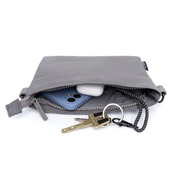 Interior del bolso pequeño color gris con llaves, móvil y airpods  hecho de plástico reciclado de la marca española Lefrik