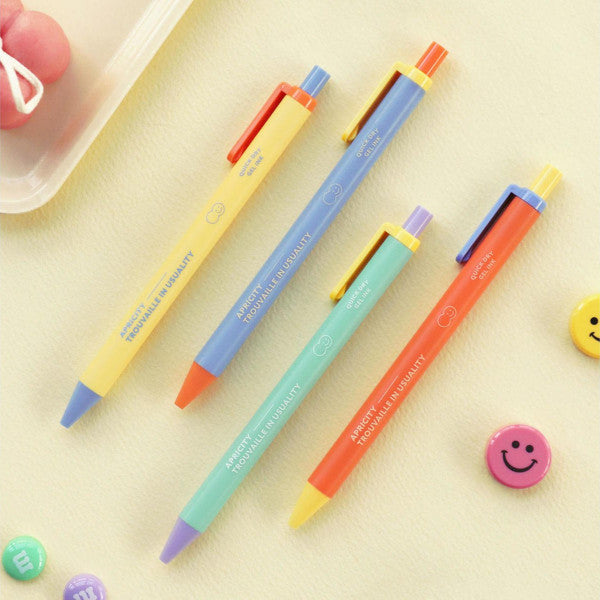 Cuatro bolígrafos de gel de colores vivos de la marca coreana Iconic junto a caritas sonrientes de colores