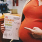 Mujer embarazada señala un libro