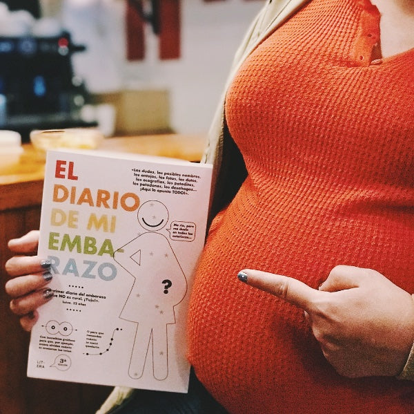 Mujer embarazada señala un libro