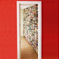 Pared forrada de libros gracias a una combinación de estanterías metálicas verticales en la pared