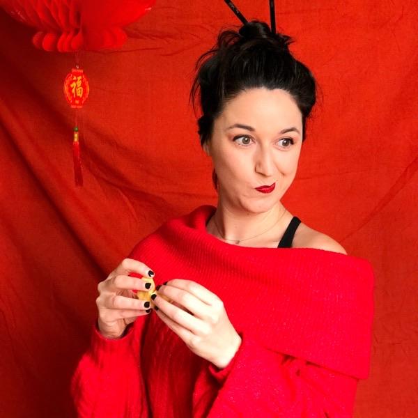 Esther Martín, de la tienda Gnomo caracterizada de china y vestida de rojo sosteniendo una galleta de la fortuna
