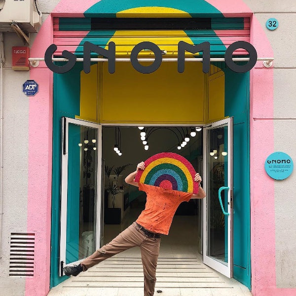 Chico sujetando felpudo con forma de arcoíris de colores