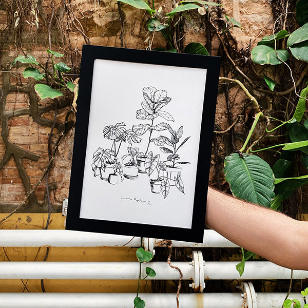 Marco negro tamaño A4 con ilustración de Laura Agustí sobre fondo de plantas