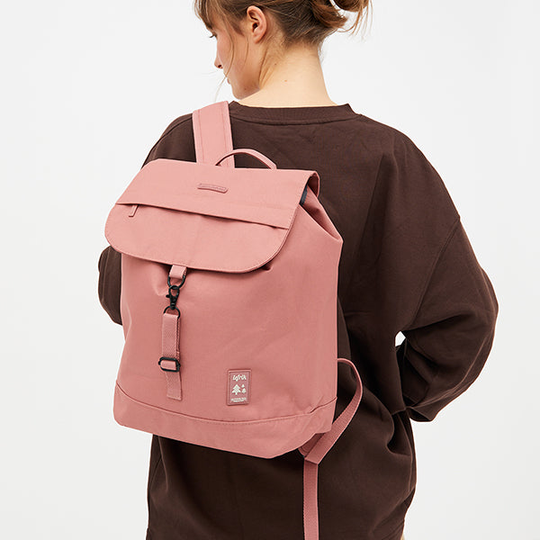 Mujer con el pelo recogido, sudadera marrón y la mochila 100% reciclada de la firma española Lefrik en color rosa empolvado