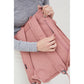 Mujer abriendo el bolsillo trasero con cremallera de la mochila rosa 100% reciclada con dos correas de la marca Lefrik