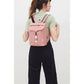 Mujer de espaldas con el pelo recogido y una mini mochila rosa de Lefrik