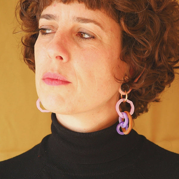 Mujer con pendientes de metacrilato con cuatro aros de colores 