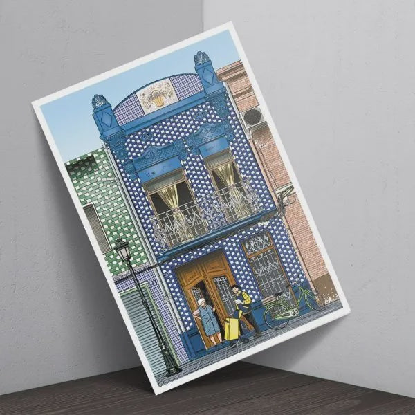 Postal con una fachada azul del barrio del Cabañal y en la puerta una señora recogiendo una carta certificada que le trae un cartero de Correos