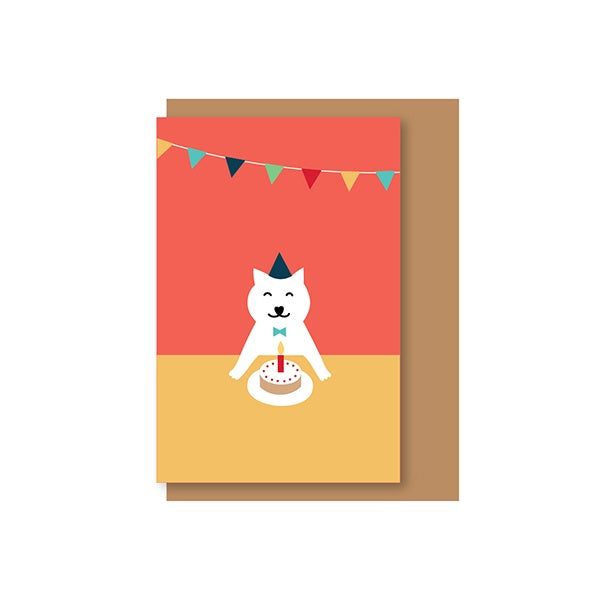 Postal de felicitación con un gato blanco sonriendo ante una tarta de cumpleaños y fondo rojo con guirnalda festiva ilustrada por Elisa Talens