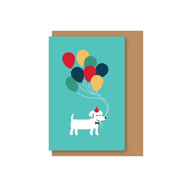 Tarjeta de felicitación con un perro con sombrerito sujetando un montón de globos de colores con el morro sobre fondo azul ilustrada por Elisa Talens